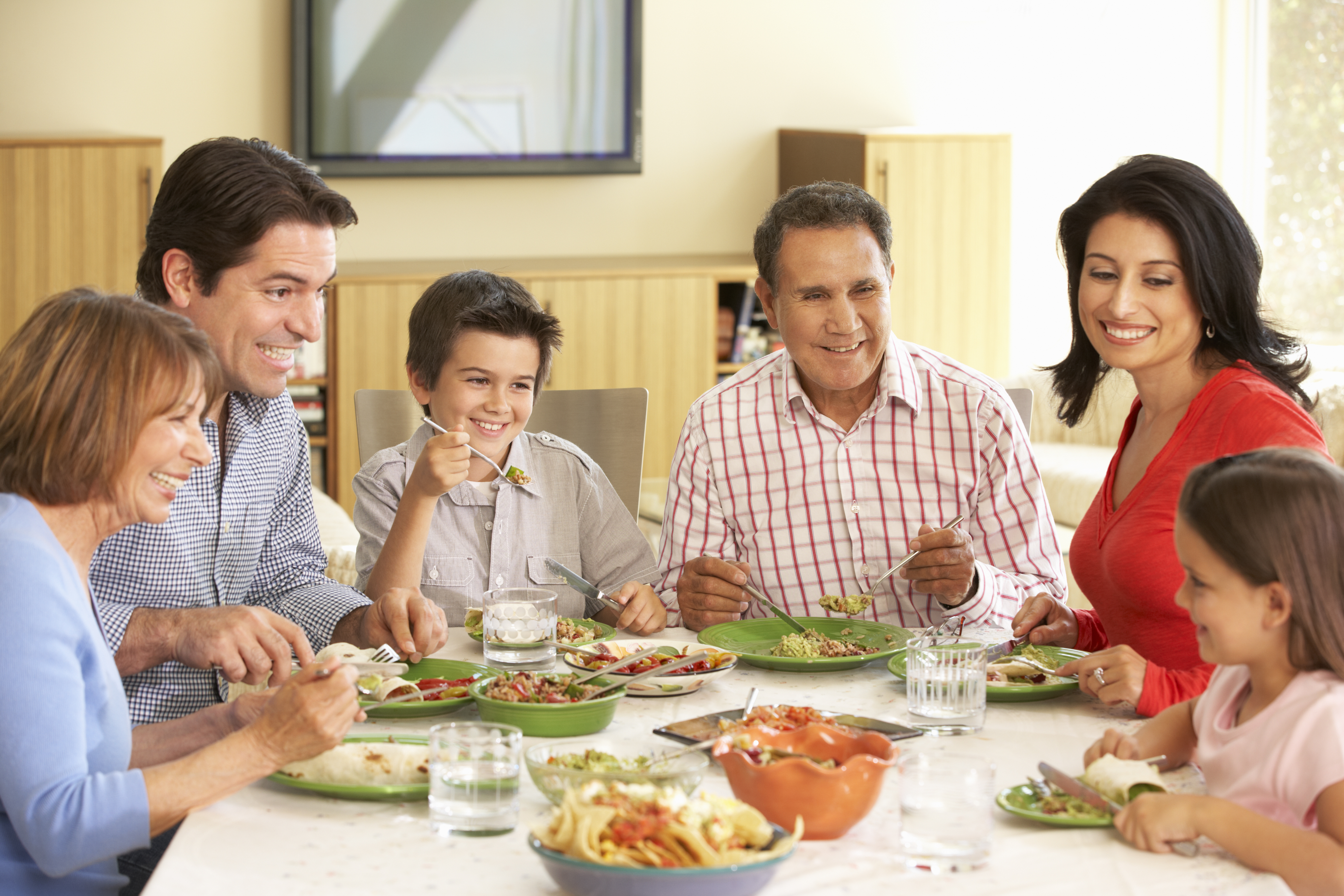 Как говорится в семье. Испанская семья за столом. Семья наслаждаются едой. Расширенная семья. Питание семьи.